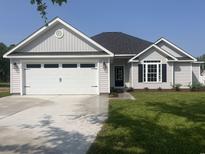 Charming single-story home with a two-car garage and well-manicured lawn at 126 Palm Dr., Loris, SC 29569