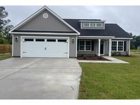 Charming single-story home features a two-car garage, gray siding, and a well-manicured lawn at 130 Palm Dr., Loris, SC 29569