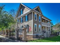 Charming two-story home with a landscaped yard, wrought iron fence, and inviting front porch at 1539 Old Town Ave., Georgetown, SC 29440