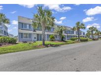 Inviting townhomes feature a well-kept lawn and blue facade complemented by lush palm trees at 1881 Colony Dr. # 8-P, Surfside Beach, SC 29575