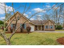 Charming brick home with blue shutters, manicured lawn, and a welcoming, attached two-car garage at 20 Brassie Dr., Carolina Shores, NC 28467