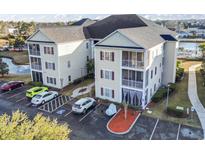 A two-story condo building displays outdoor patios, designated parking, and colorful landscape features at 2070 Cross Gate Blvd. # 201, Surfside Beach, SC 29575