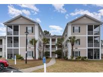 Inviting condo complex featuring manicured lawns, palm trees, and reserved parking at 242 Sun Colony Blvd. # 203, Longs, SC 29568