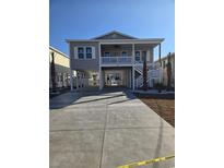 Charming elevated beach house with covered parking, stairs, and a front porch with a white railing at 326 46Th Ave. N, North Myrtle Beach, SC 29582