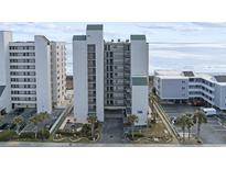 Coastal condo building featuring a beachside view, balconies, and well-maintained landscaping at 4301 S Ocean Blvd. # 1-B, North Myrtle Beach, SC 29582