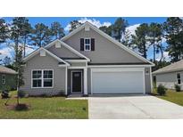 Charming single-Gathering home with gray siding, an attached garage and a well-maintained lawn at 4525 East Coast Ln., Shallotte, NC 28470