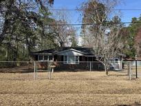 Cozy brick home with a fenced yard, mature trees, and an inviting entrance at 57 Tallahassee Rd., Georgetown, SC 29440