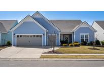 Charming one-story home featuring a blue exterior, attached garage, and well-maintained landscaping at 7122 Sarteano Dr., Myrtle Beach, SC 29577