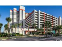Bright multi-story condo resort with a parking garage, palm trees, and easy beach access at 7200 N Ocean Blvd. # 255, Myrtle Beach, SC 29572