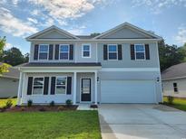 Charming two-story home with a manicured lawn and a two-car garage, under a sky with light clouds at 918 Agostino Dr., Myrtle Beach, SC 29579