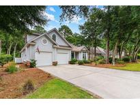 Charming home featuring an attached two-car garage and well-manicured front lawn with mature trees at 921 Heshbon Dr., North Myrtle Beach, SC 29582