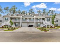 Charming townhome with dual staircases and a shared driveway leading to attached garages at 940 Jackline Place # 202, Murrells Inlet, SC 29576