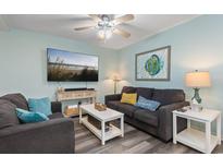Relaxing living room featuring comfortable seating, modern decor, and a large screen TV for entertainment at 9661 Shore Dr. # A-21, Myrtle Beach, SC 29572