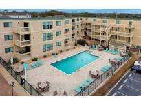 Aerial view of community pool surrounded by lounge chairs and tables at condo complex at 9661 Shore Dr. # A-21, Myrtle Beach, SC 29572