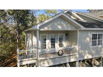 Cozy front porch featuring white railings, French doors, and a decorative wreath at 98 Wallys Way # 1, Pawleys Island, SC 29585