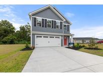 Charming two-story home featuring gray siding, black shutters, a red front door, and an attached two-car garage at 1023 Oak Meadow Dr., Conway, SC 29526