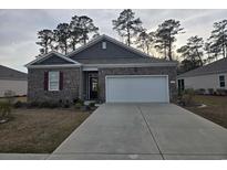 Charming brick home featuring a two-car garage and well-maintained landscaping at 1119 Maxwell Dr., Little River, SC 29566