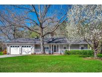 Charming single-story home featuring a well-manicured lawn, a welcoming front porch, and mature trees at 1278 Pinetucky Dr., Galivants Ferry, SC 29544