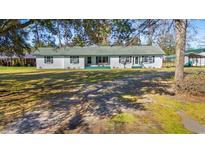 Charming single-story home with a green roof, shutters, and a spacious front yard at 1861 Jenerette Rd, Mullins, SC 29574