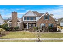 Charming brick home featuring blue shutters, manicured lawn, and a welcoming front entrance at 1909 Bingham Ct., Myrtle Beach, SC 29588