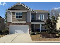 Charming two-story home with a two-car garage, stone accents, and a well-manicured front yard at 204 Juniata Loop, Little River, SC 29566