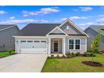 Charming single-story home with attached garage, lovely landscaping, and inviting front porch at 2135 Gooseberry Way, Longs, SC 29568