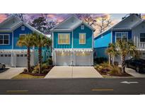 Charming teal two-story home with a double garage and palm trees at 2406 Seabreeze Pl., Myrtle Beach, SC 29577
