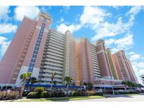 Stunning exterior view of a beachfront condo complex with palm trees and manicured landscaping at 2701 S Ocean Blvd. # 202, North Myrtle Beach, SC 29582