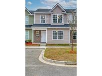 Charming two-story townhome with beige siding, brick accents, and a well-manicured lawn at 2705 Mercer Dr. # 2705, Conway, SC 29526