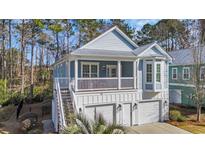 Charming two-story home featuring a double garage, elevated porch, and coastal-inspired architecture at 28 Big Oak Pl., Pawleys Island, SC 29585