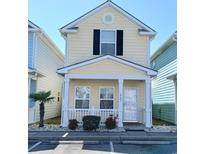 Charming yellow two-story home with a cozy front porch and white picket fence near parking at 337 Sailors Ct., Myrtle Beach, SC 29577