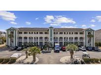 Wide shot of the building featuring a parking lot, balconies, and palm trees at 4520 N Plantation Harbour Dr. # F9, Little River, SC 29566