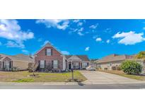 Charming brick home with a manicured front yard and ample parking on a sunny day at 7 Picket Fence Ln., Calabash, NC 28467