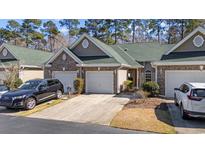 Charming townhome with a well-manicured lawn, two-car garage, and brick accents at 750 Pinehurst Ln. # 84C, Pawleys Island, SC 29585