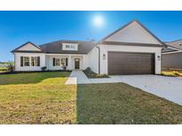 Inviting single-Gathering home with a well-manicured lawn and attached two-car garage at 1064 Merritt Rd, Conway, SC 29526