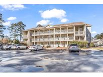 Exterior shot of condominiums with multiple levels and balconies, surrounded by well-maintained landscaping and parking at 1230 St. George Ln. # F, Myrtle Beach, SC 29588