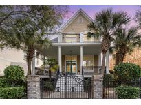 Charming two-story home features double-decker balconies, a gated entryway, and lush landscaping at 1523 James Island Ave., North Myrtle Beach, SC 29582