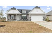 Charming home featuring gray siding, a white garage door, and a well-manicured lawn at 179 Crabapple Dr., Longs, SC 29568