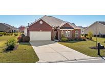 Charming single-story brick home featuring an attached garage and a well-manicured front yard at 221 Shenandoah Dr., Murrells Inlet, SC 29576
