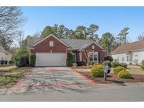 Charming brick home with a well-manicured lawn and an attached two-car garage at 2911 Winding River Dr., North Myrtle Beach, SC 29582