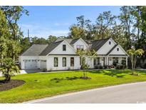 Beautiful two-story home with white siding, dark roof, manicured lawn, and attached two-car garage at 595 Wilcox Ave., Murrells Inlet, SC 29576