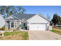 Charming home featuring stone accents, an attached two-car garage, and meticulously maintained landscaping at 804 Twickenham Loop, Longs, SC 29568