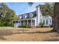 Charming white two-story home with a welcoming front porch and upper level deck at 81 Woodpecker Ln., Pawleys Island, SC 29585