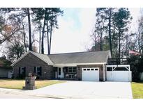 Charming brick ranch-style home with a well-manicured lawn, a driveway, and a one-car garage at 111 Willow Ridge Rd., Myrtle Beach, SC 29588