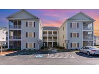 Inviting condo building features multiple levels, parking, and charming exterior details at 2060 Cross Gate Blvd. # 104, Surfside Beach, SC 29575