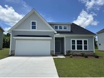Charming single-Gathering home with a two-car garage, stone accents, and manicured lawn on a sunny day at 212 Sundrop Way, Conway, SC 29526
