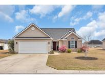 Charming single-story home featuring a well-manicured lawn and a two-car garage at 216 Camrose Way, Myrtle Beach, SC 29579