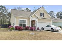 Charming single-Gathering home featuring a well-maintained lawn, blooming shrubs, and a two-car garage at 275 Castaway Key Dr., Pawleys Island, SC 29585