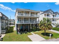 Two-story beach house with double balconies and a neatly kept lawn and palm tree at 4620 Surf St., North Myrtle Beach, SC 29582