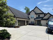 Charming two-story home features a large driveway, two-car garage, and beautiful landscaping at 9785 Anchor Dr., Longs, SC 29568